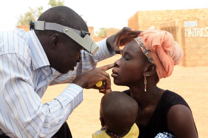 An outdoor examination of a woman’s right eye, looking for symptoms of trachoma/CDC