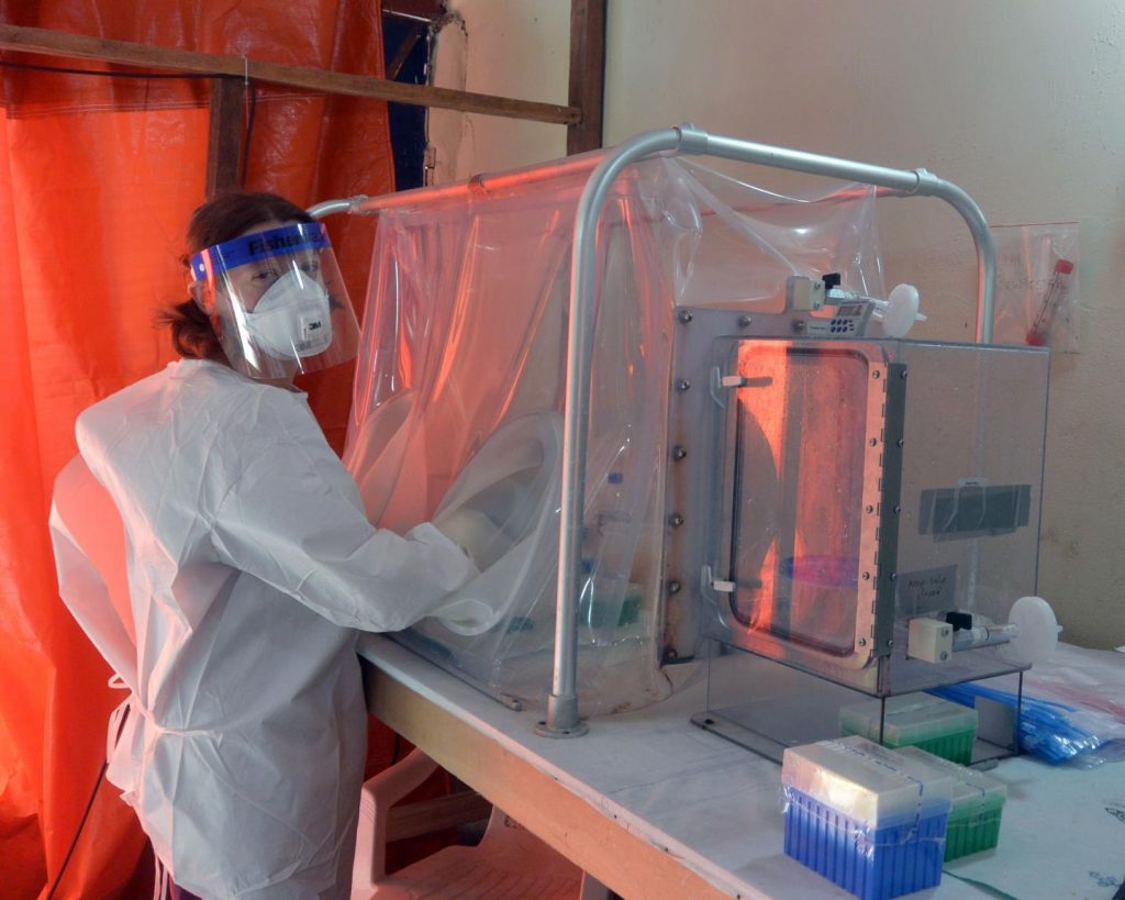 One of the NIAID study authors, Emmie de Wit, is shown at the diagnostic laboratory in Monrovia using a sealed glovebox to inactivate virus in patient blood samples prior to testing for Ebola/NIAID
