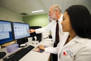 Daniel Hoft, M.D. Ph.D., director of SLU's division of infectious diseases, and Catherine Cai, a SLU MD/PhD candidate, review data that shows detailed information about characteristics of individual T cells at SLU's flow cytometry research core. CREDIT Saint Louis University